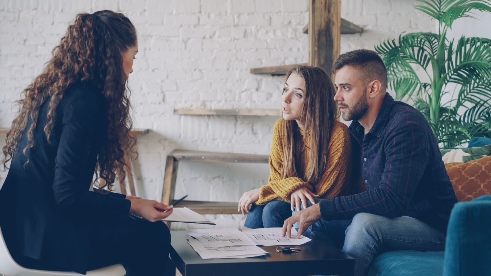 A couple in conversation with a professional adviser at a desk