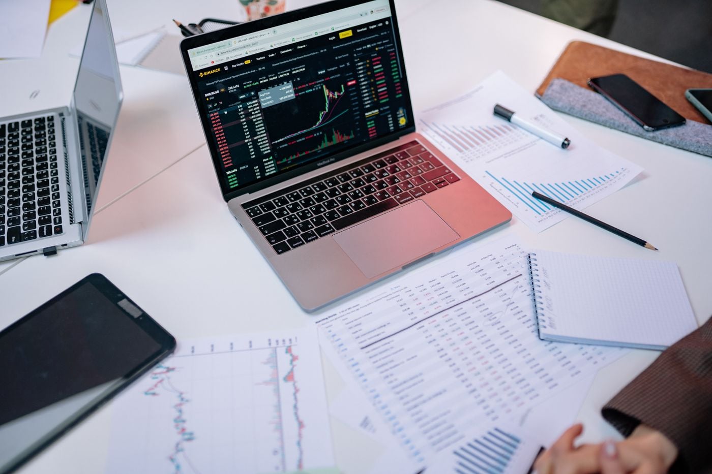 Financial charts, documents and a laptop prepared for analysis