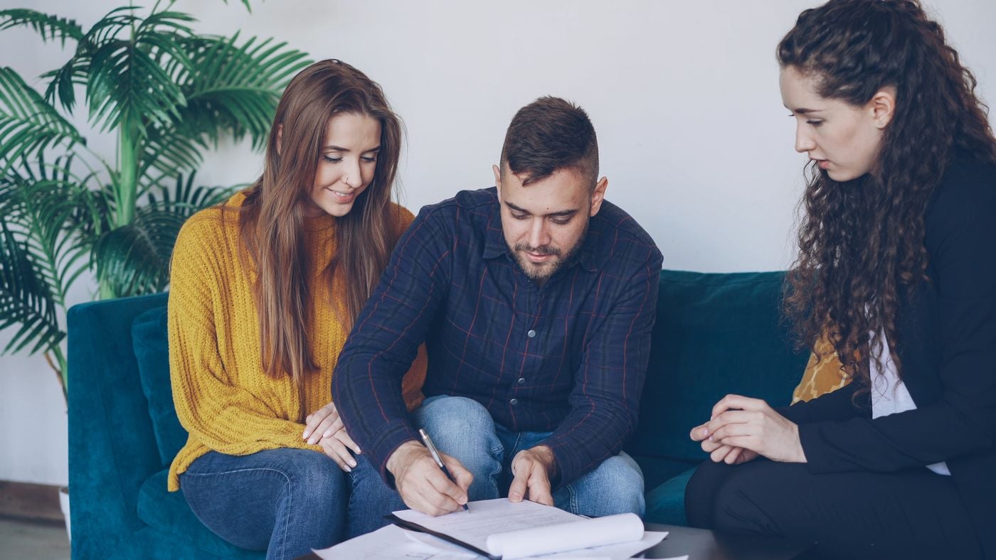 Clients reviewing and signing documents with an adviser