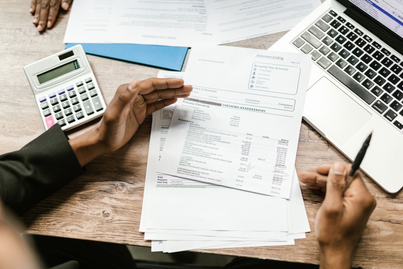 Financial reports reviewed alongside a laptop and calculator