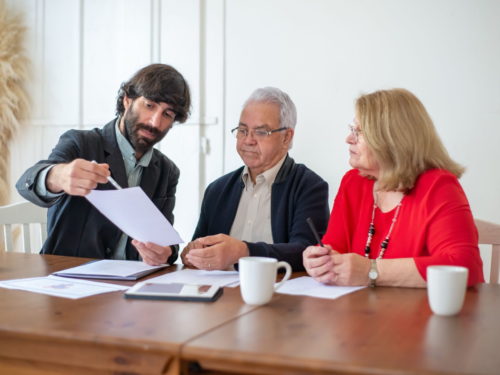 A consultant discussing documents with a couple at a table