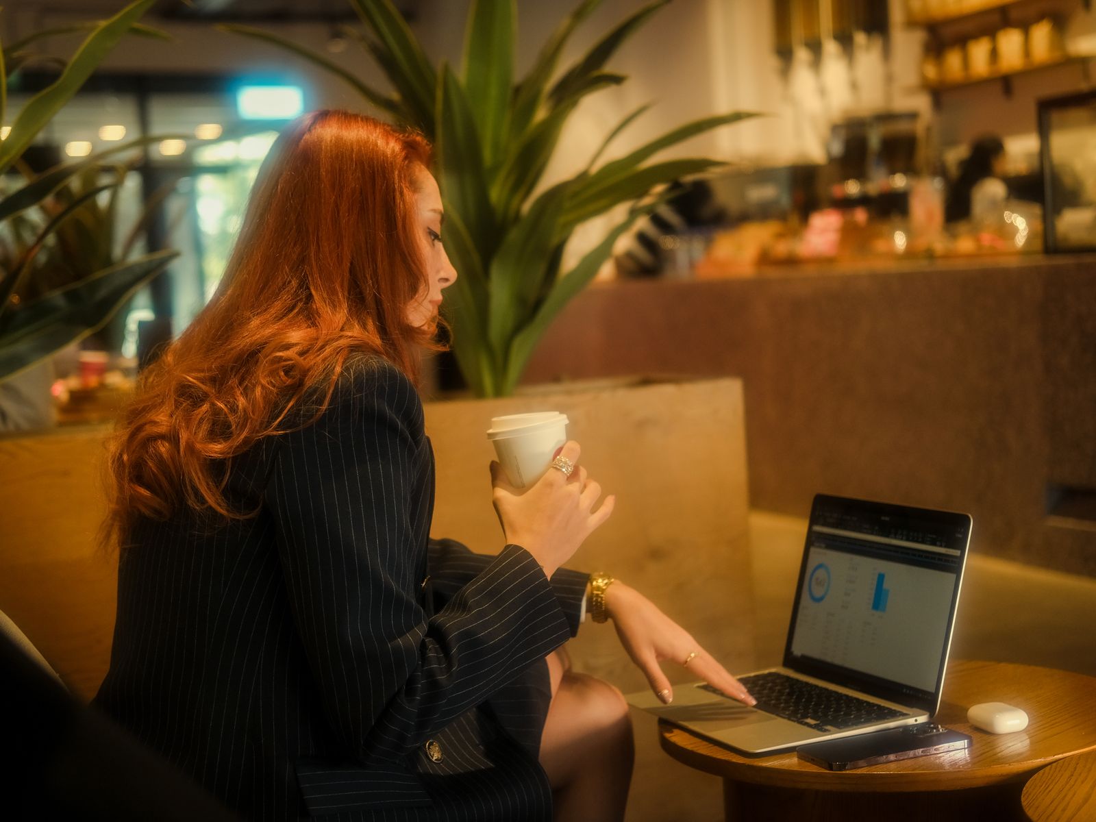 A professional working on a laptop in a café